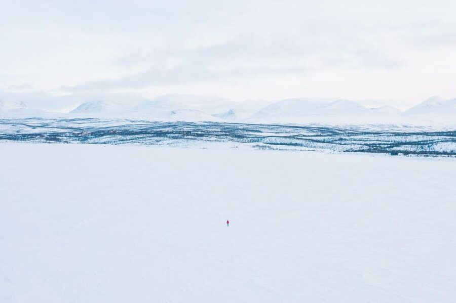 Abisko: Lake Torneträsk Arctic Ice Fishing Trip - Fishing for Arctic char through frozen water
